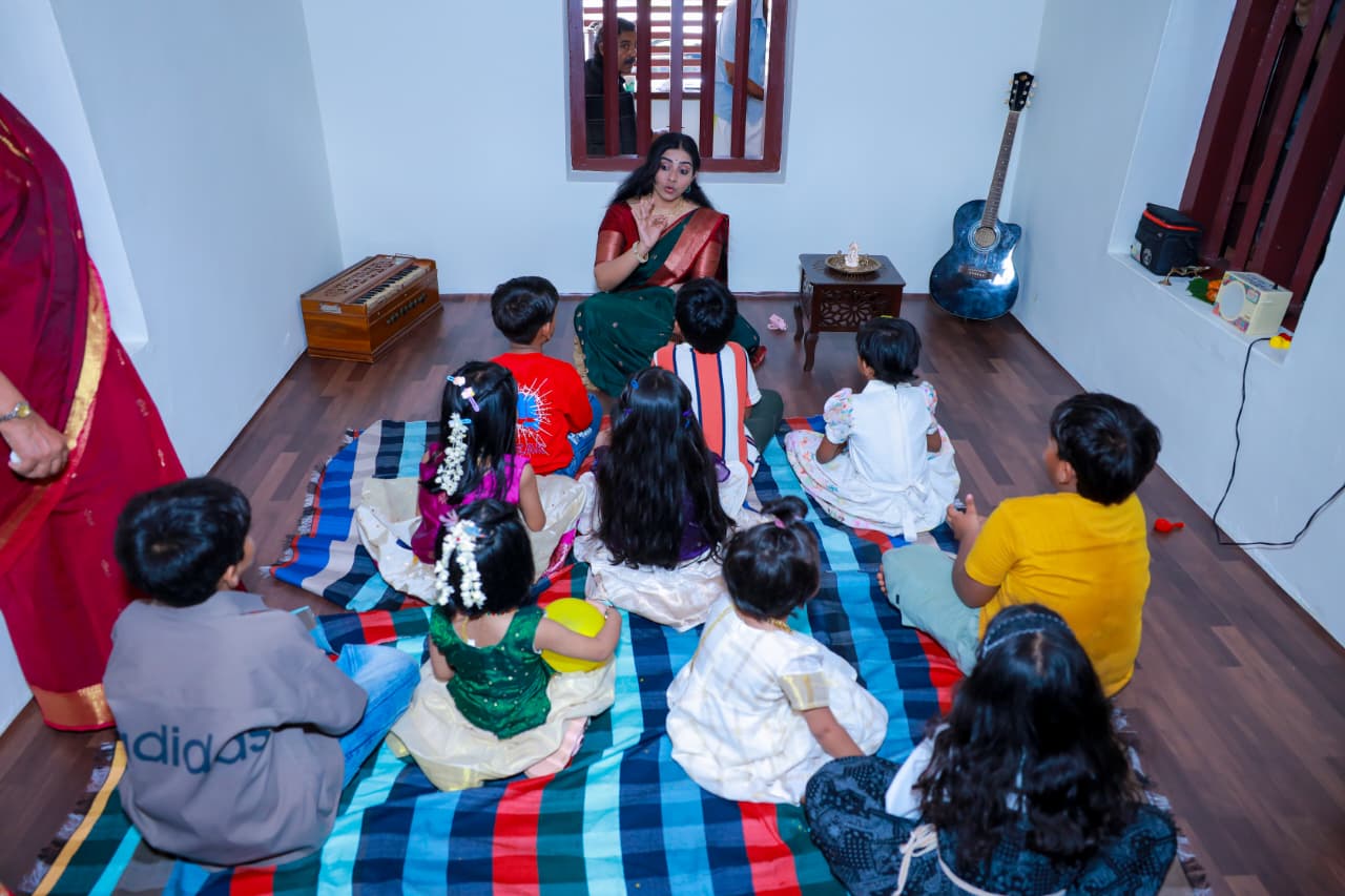 Children seated in a circle during a music class led by Sarvasri Sukesh