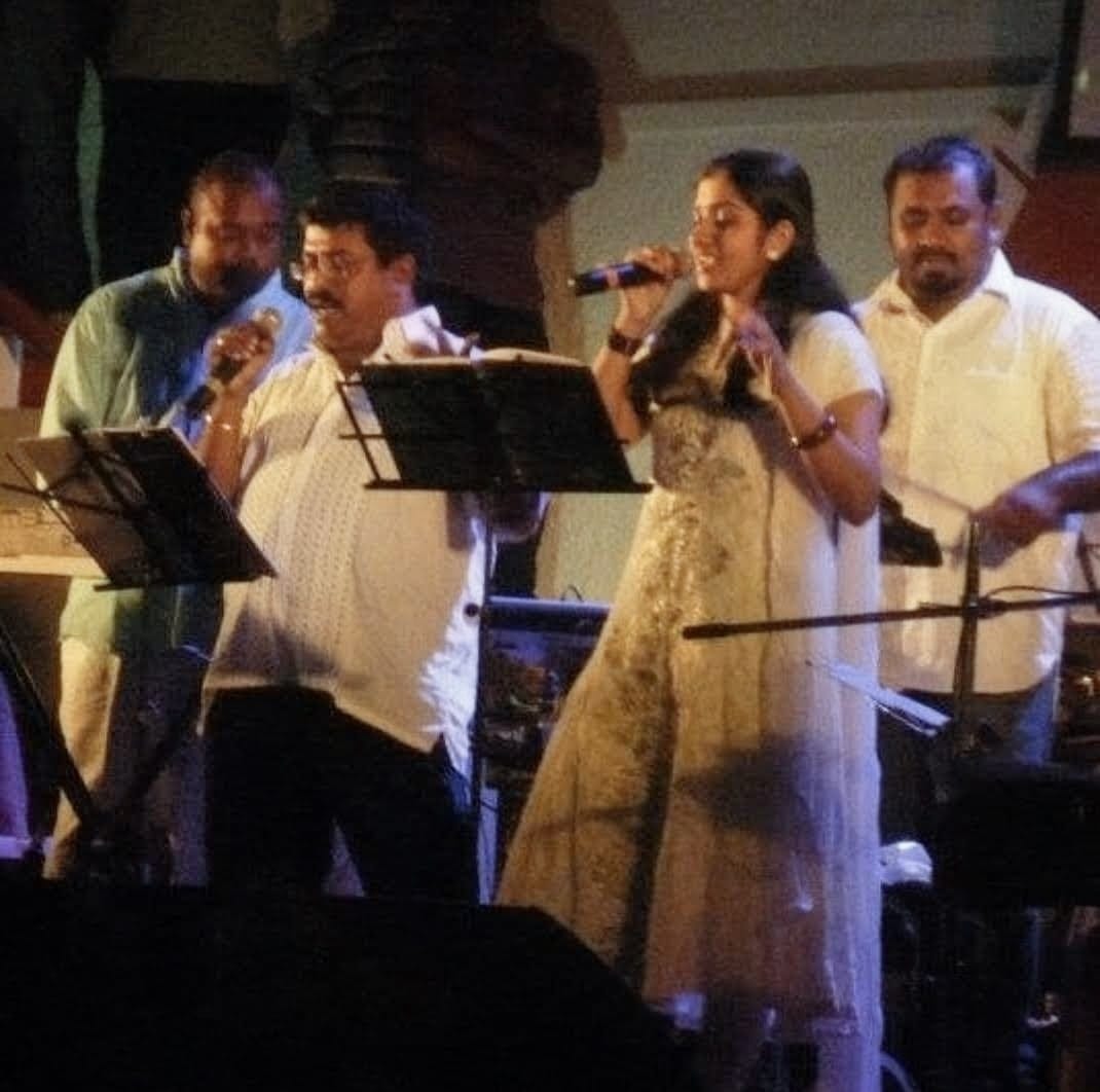 Sarvasri Sukesh performing live on stage with a music band